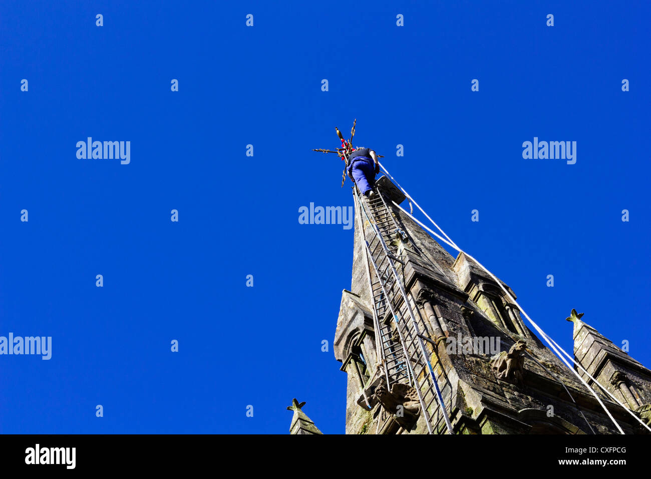 Klettermax an Spitze der Kirchturm auf langen Leitern. Stockfoto