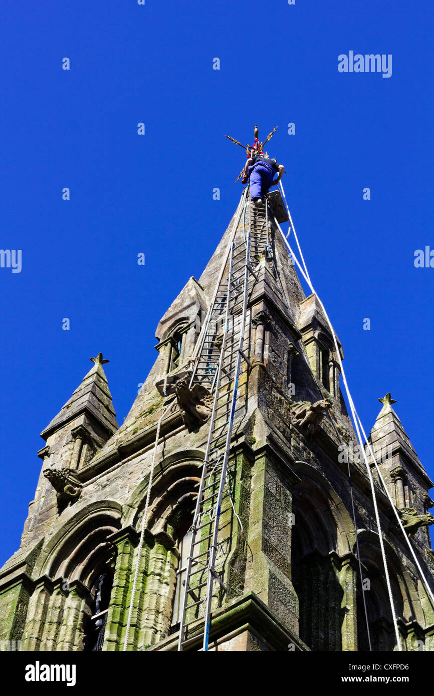 Klettermax an Spitze der Kirchturm auf langen Leitern. Stockfoto