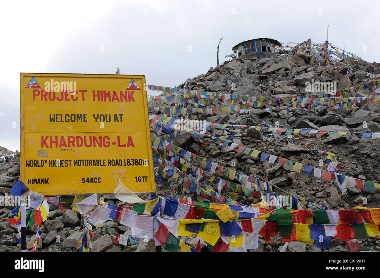 Gebetsfahnen und Zeichen an der Spitze der was behauptet, der weltweit höchste befahrbare Straße passieren, Khardung La. Stockfoto