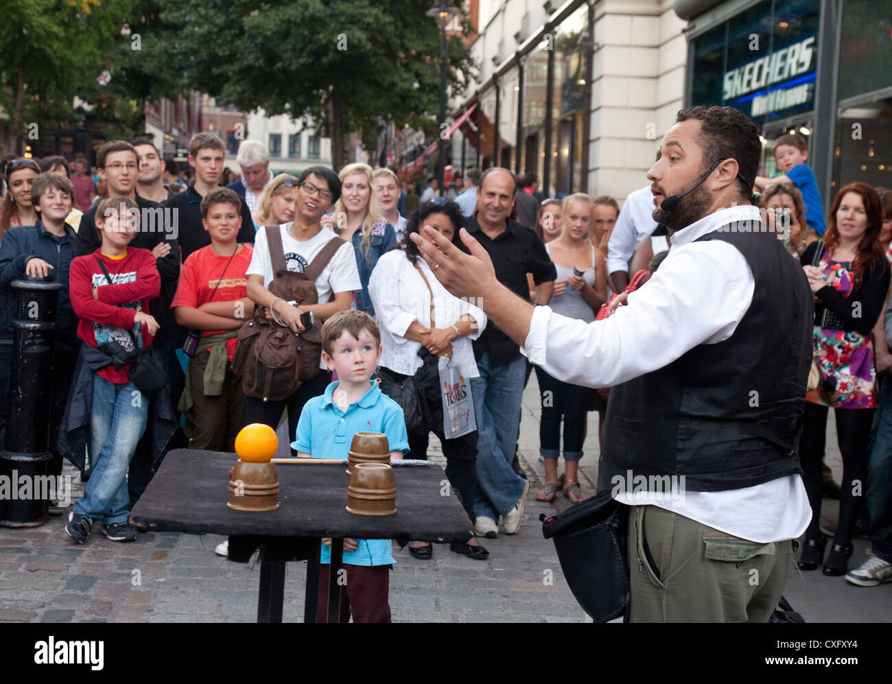 Ein junges Kind gerade eine Straße Entertainer durchführen, Covent Garden, London UK Stockfoto