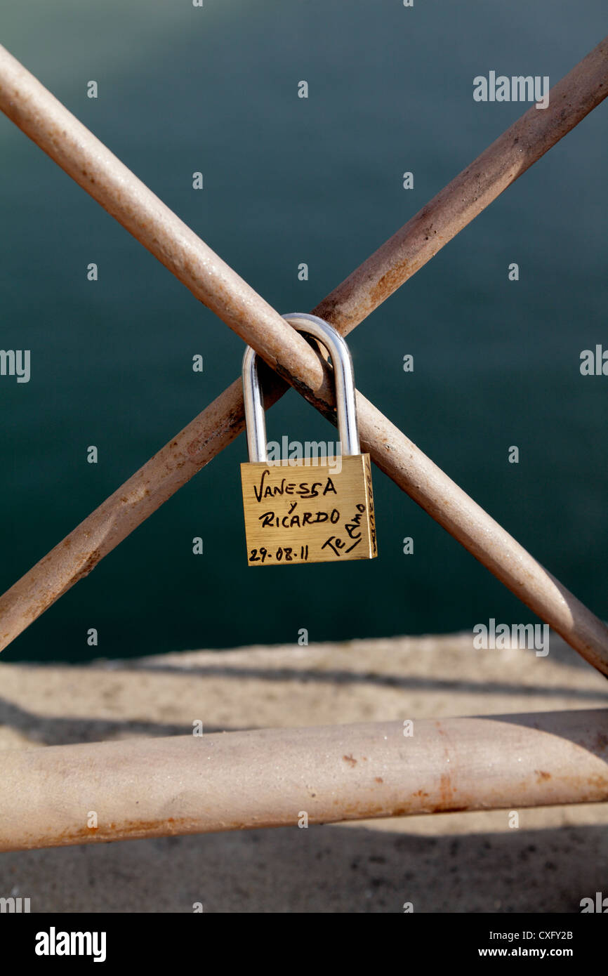 Liebe token Vorhängeschloss mit ein paar Namen auf dem Geländer der Isabella II Brücke über den Fluss Guadalquivir eine einzige Stockfoto