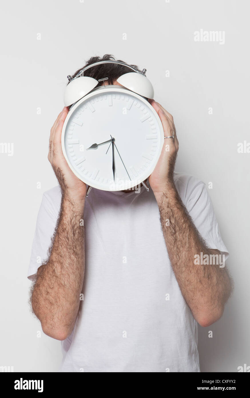 Ein junger Mann mit einem großen Retro-Style Uhr vor den Kopf gelegt. Stockfoto
