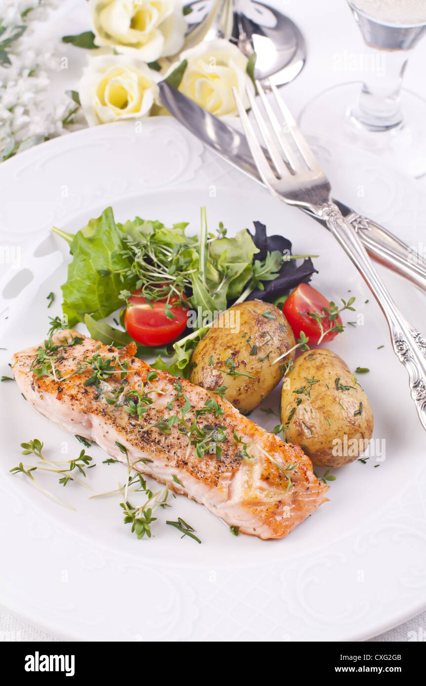 Lachssteak mit Paket-Kartoffeln und Salat Stockfoto