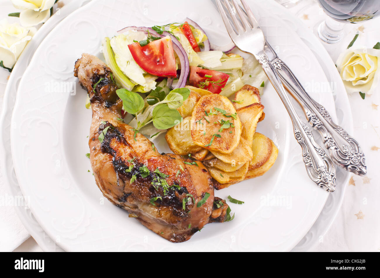 Hähnchenschenkel gegrillt mit Pommes Frites und Salat Stockfoto