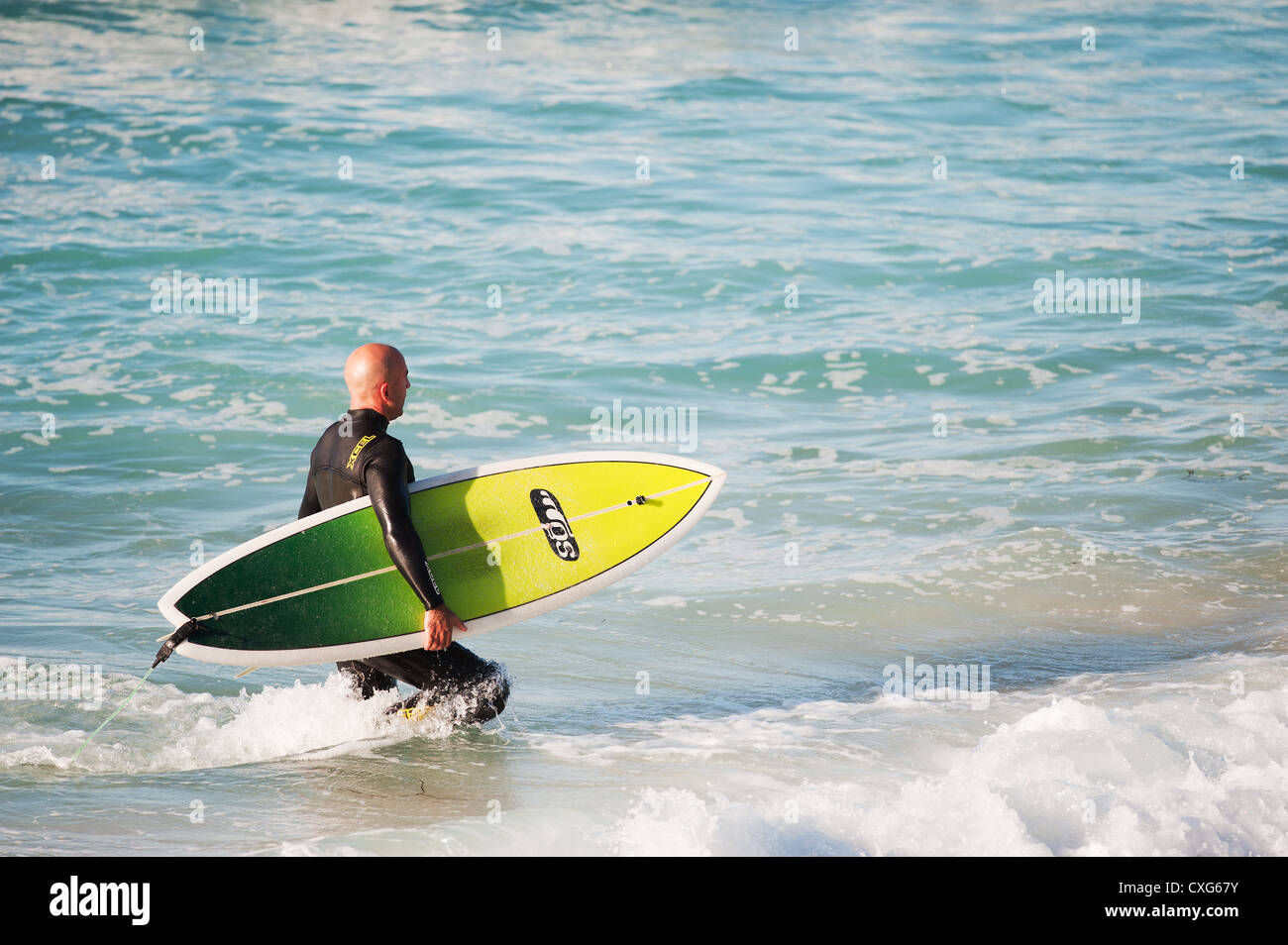 Ein Surfer, ein Spaziergang durch das Meer bei Sennen in Cornwall Stockfoto