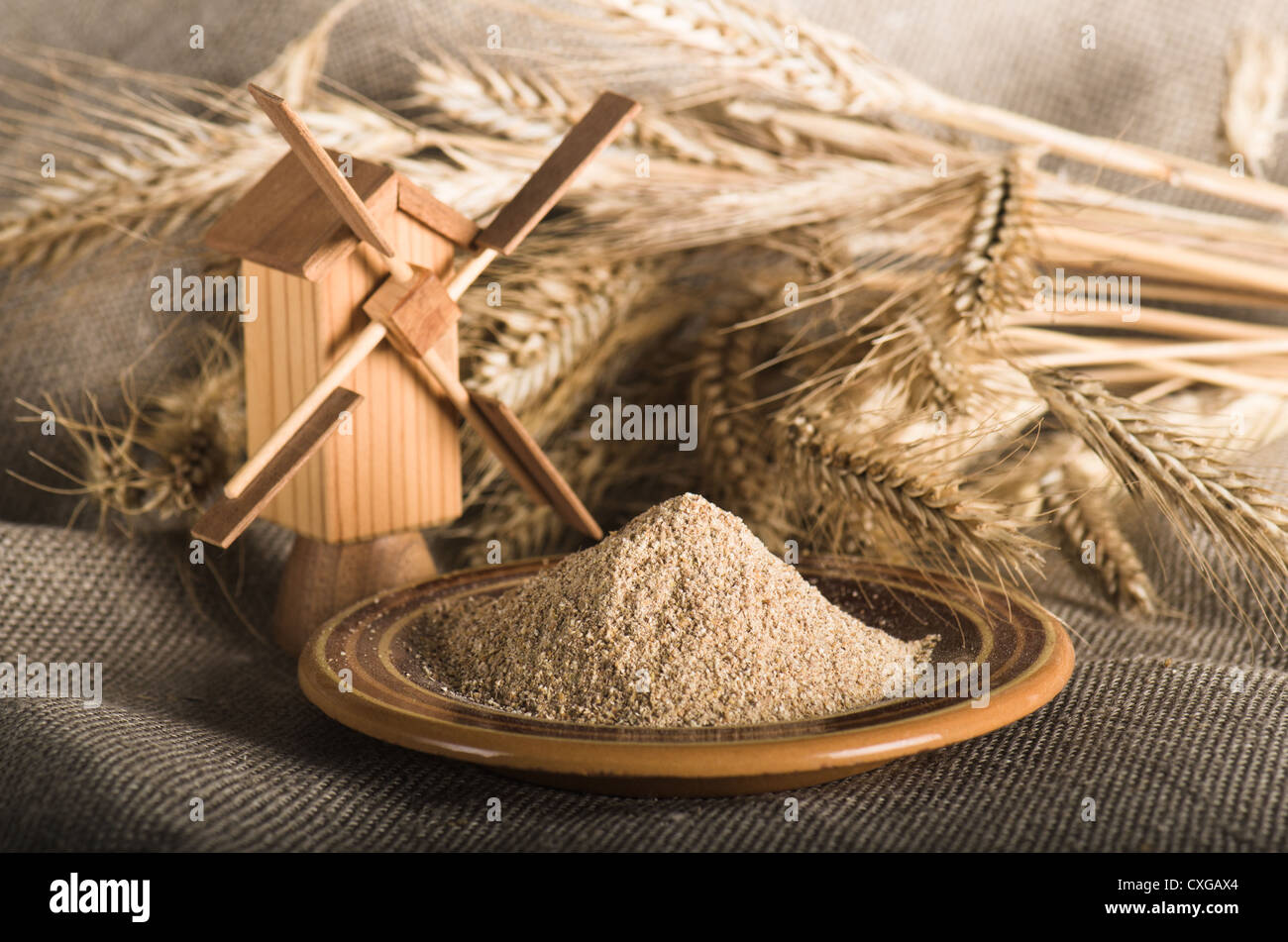Vollkornmehl und Weizen auf Tuch Sack, Nahaufnahme Stockfoto