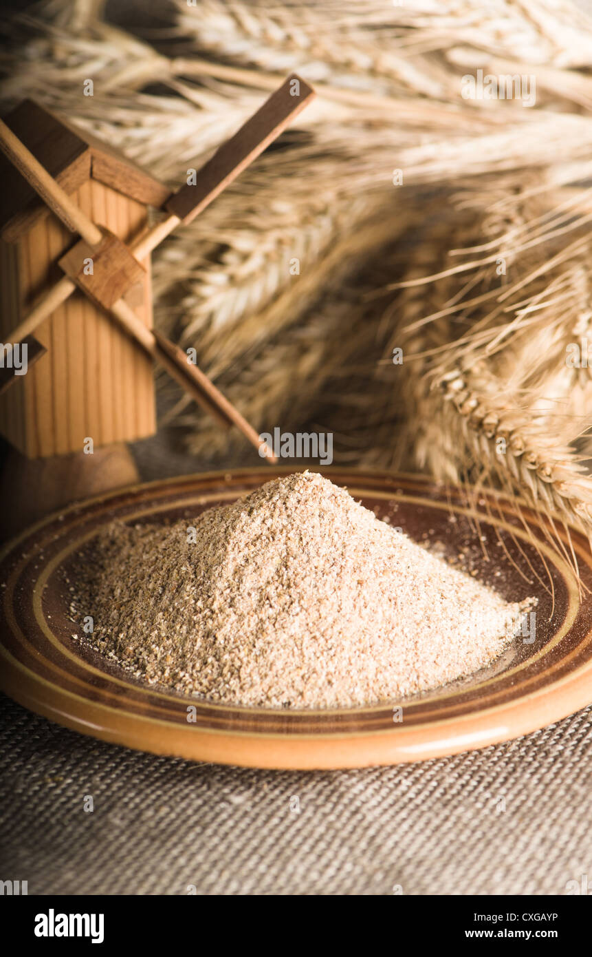 Vollkornmehl und Weizen auf Tuch Sack, Nahaufnahme Stockfoto