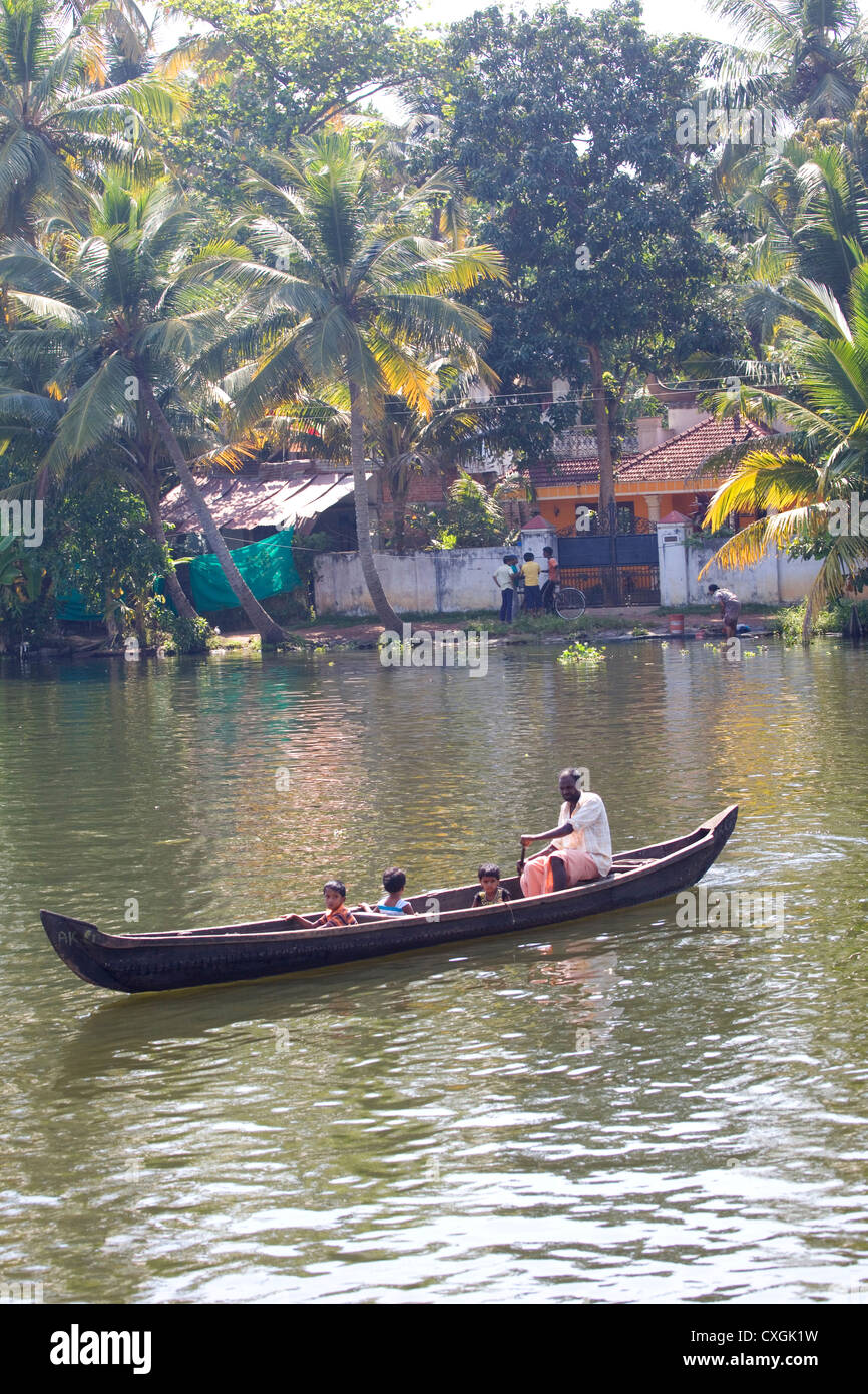 Ein Familienausflug in einem hölzernen Tradition Kanu durch die Backwaters von Alleppey, Kerala, Indien. Stockfoto