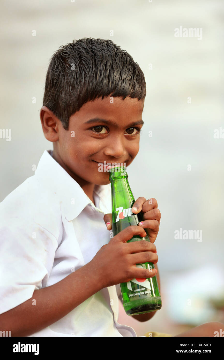 Indische Schuljunge trinken ein Erfrischungsgetränk 7up Andhra Pradesh in Indien Stockfoto