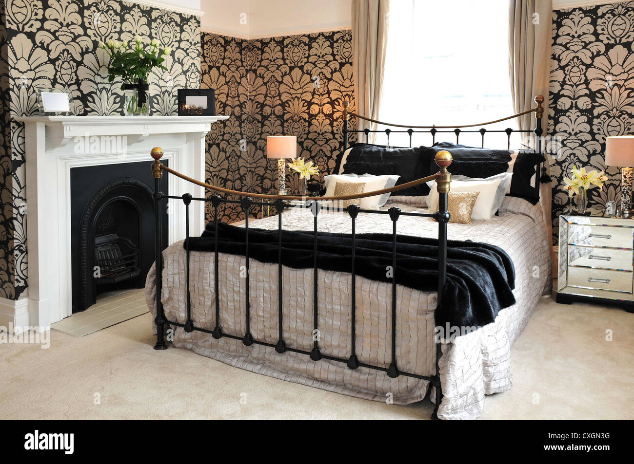 Ein Innenraum gestaltete Schlafzimmer mit Bett, Kamin und Blumentapete  Stockfotografie - Alamy