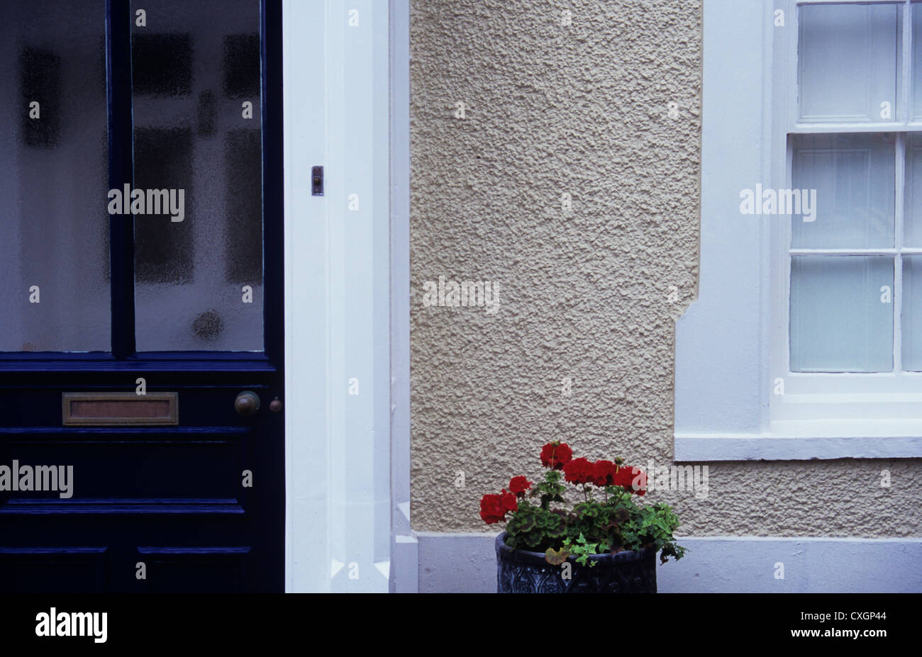 Detail des Hauses mit schwarz bemalt, Außentür weiße Innentür weiße Fenster und Tür umgibt und graue pebbledash Stockfoto