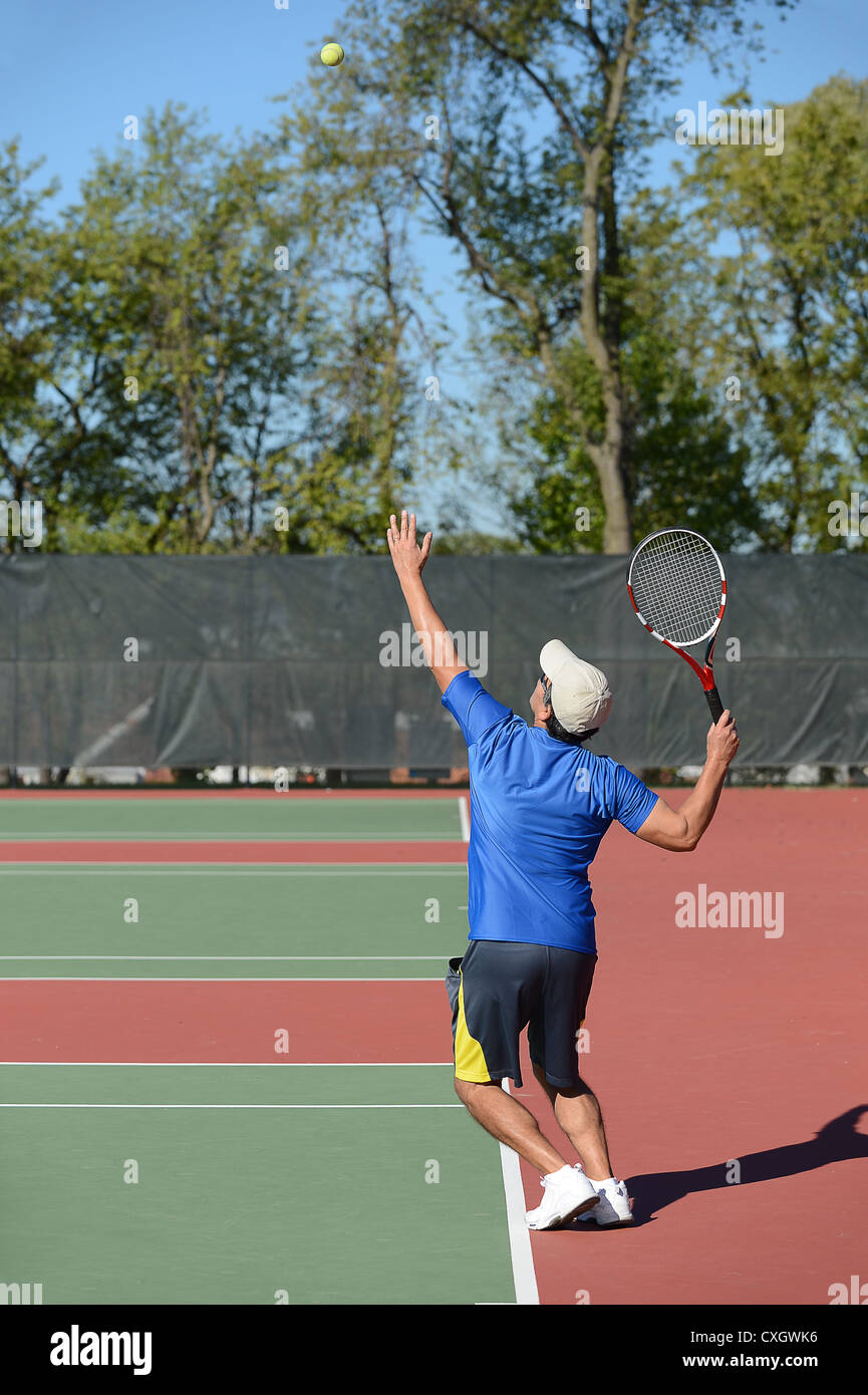 Reifer Mann mit dem Tennisspielen auf Platz Stockfoto