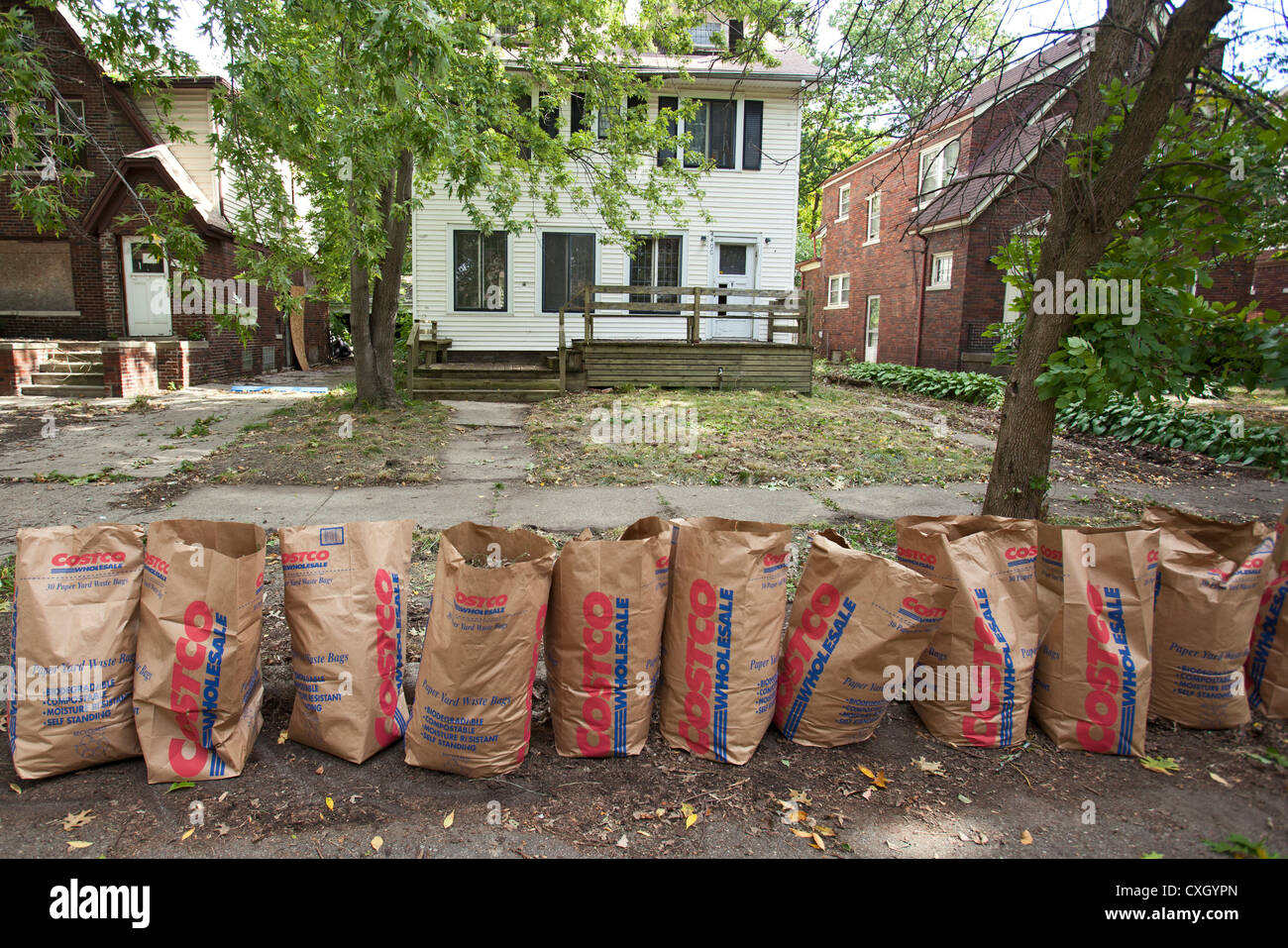 Eine Reihe der Hof Müllbeutel ist zur Abholung bereit, nachdem die drei Meile fahren Block Club den Rasen eines leeren Hauses gereinigt Stockfoto