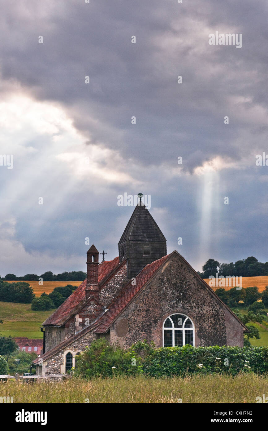 St. Huberts Church in Idsworth Hampshire mit Strahlen der Sonne durch die Wolken kommen aus dem Osten suchen Stockfoto