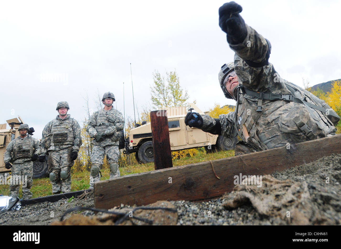 SPC. Eduardo Jacome von der 545. Militärpolizeikompanie übt, eine Handgranate aus einem Fuchsloch auf die Kraft Handgranatenanlage auf der Joint Base Elmendorf-Richardson, Alaska, zu werfen, um die Granatfähigkeiten zu erneuern. Stockfoto