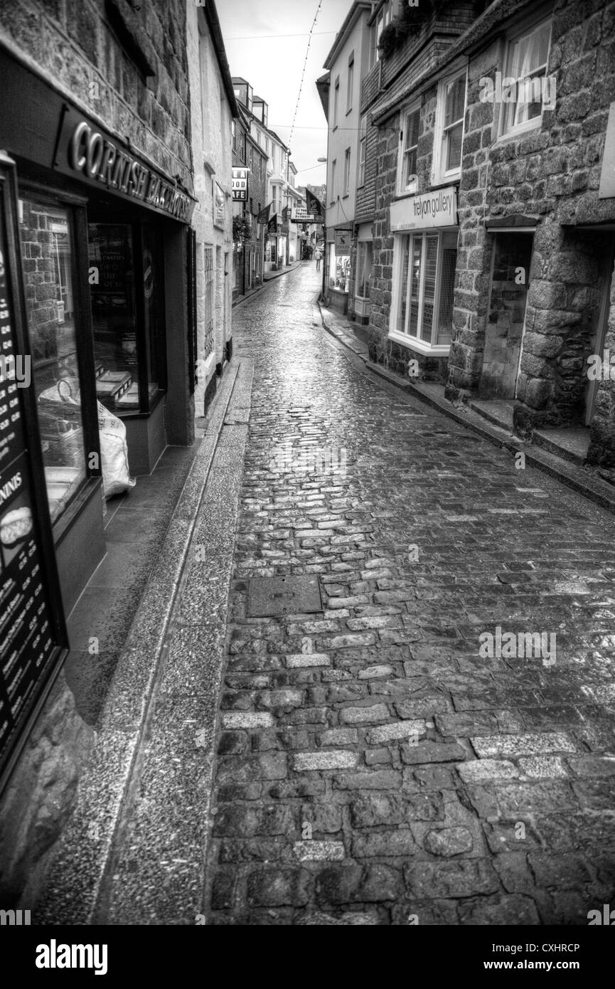 St. Ives, Cornwall Einkaufsstraße in schwarz und weiß in den Regen, gepflasterten Straße, vorbei an Geschäften Stockfoto