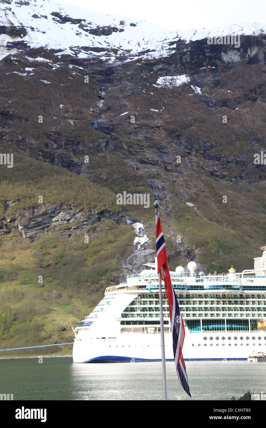 Schöne Geiranger in den norwegischen Fjorden mit Kreuzfahrtschiff im Hintergrund. Stockfoto