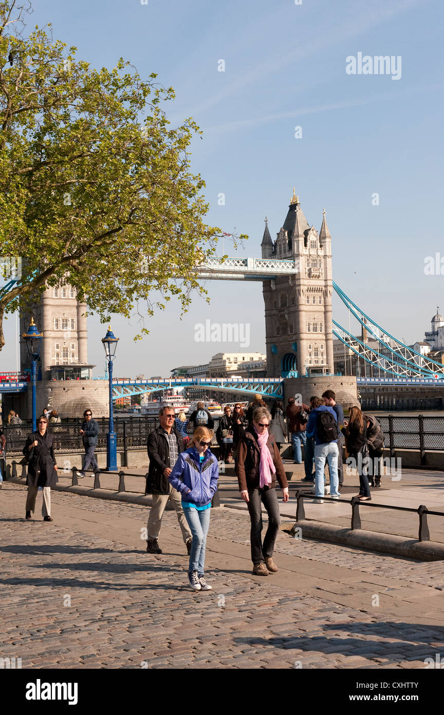 Touristen genießen Sie einen Spaziergang an der Themse mit Tower Bridge im Hintergrund, London, England. Stockfoto