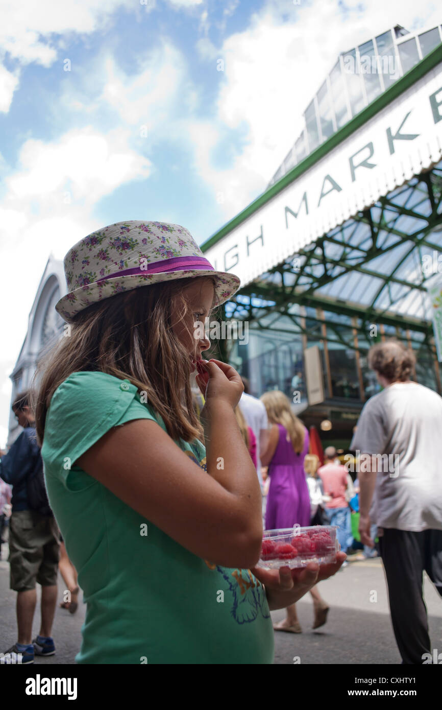 Mädchen essen Himbeeren in den Borough Market in London. Stockfoto