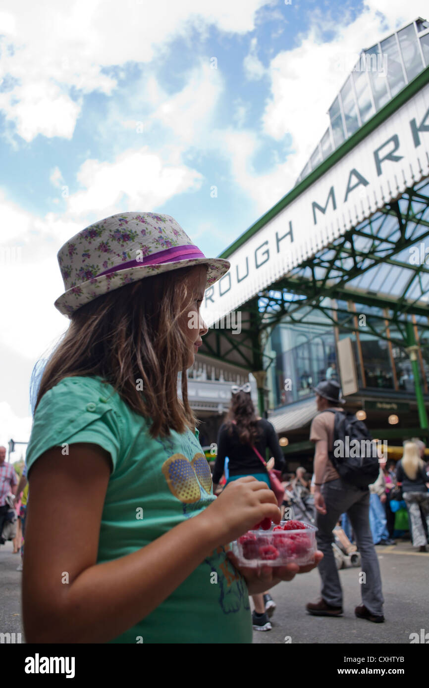 Mädchen essen Himbeeren in den Borough Market in London. Stockfoto