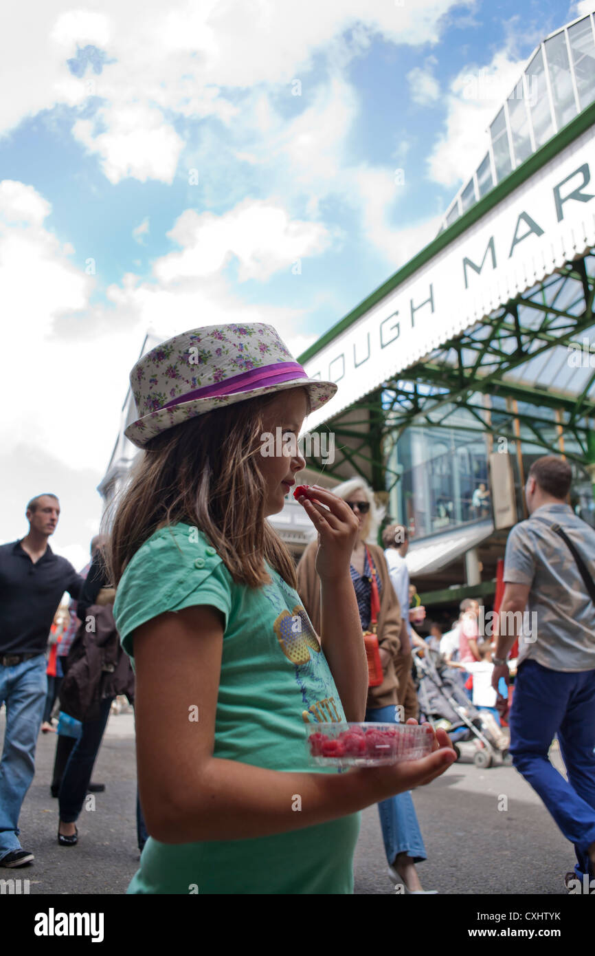 Mädchen essen Himbeeren in den Borough Market in London. Stockfoto