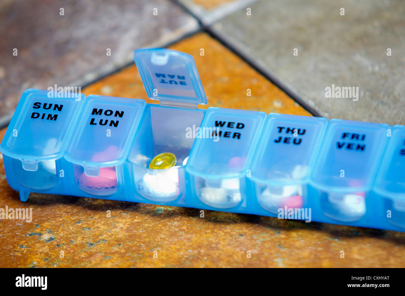 Eine wöchentliche Vitamin und Pille Veranstalter, auf einem Schieferfliese Tisch. Stockfoto