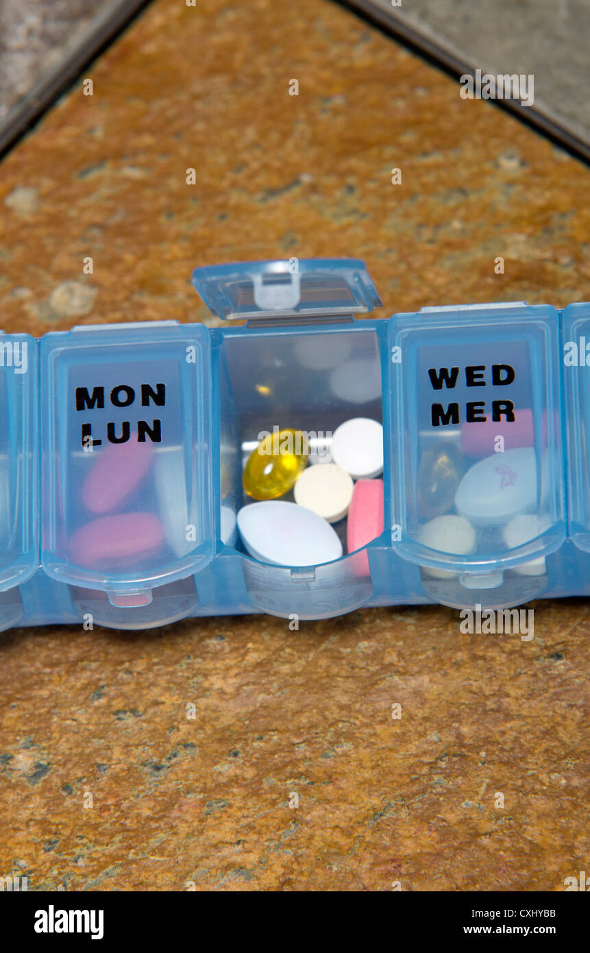Eine wöchentliche Vitamin und Pille Veranstalter, auf einem Schieferfliese Tisch. Stockfoto