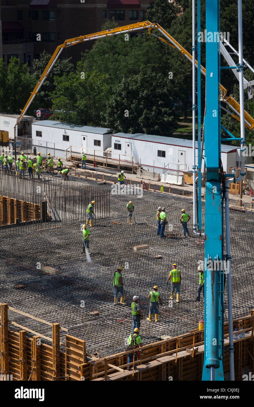 Arbeiter Gießen Zement über Bewehrung auf Baustelle. Stockfoto