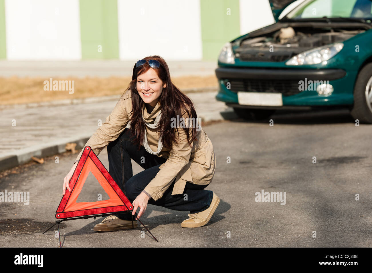 Frau, die Auto Aufschlüsselung Schild Warndreieck aufsetzen Stockfoto