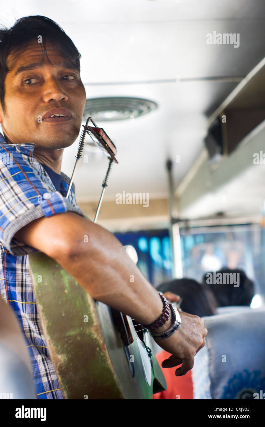Eine indonesische Mann als Straßenmusikant durch das singen in den Bus, Asien-Szene. Leichte Bewegung Shakes sind bei 100 % Zoom sichtbar. Stockfoto