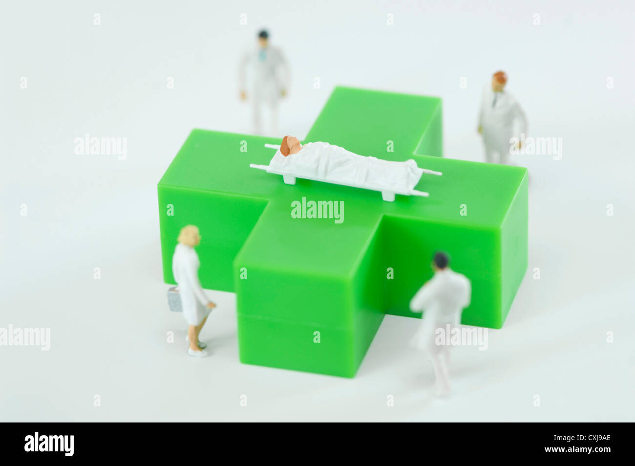 Figuren von Ärzten und Patienten mit grünen medizinischen symbol Stockfoto