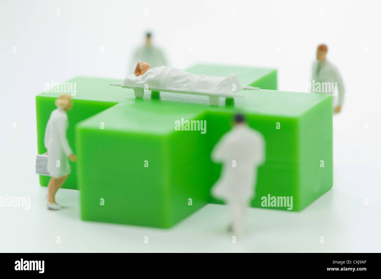 Figuren von Ärzten und Patienten mit grünen medizinischen symbol Stockfoto