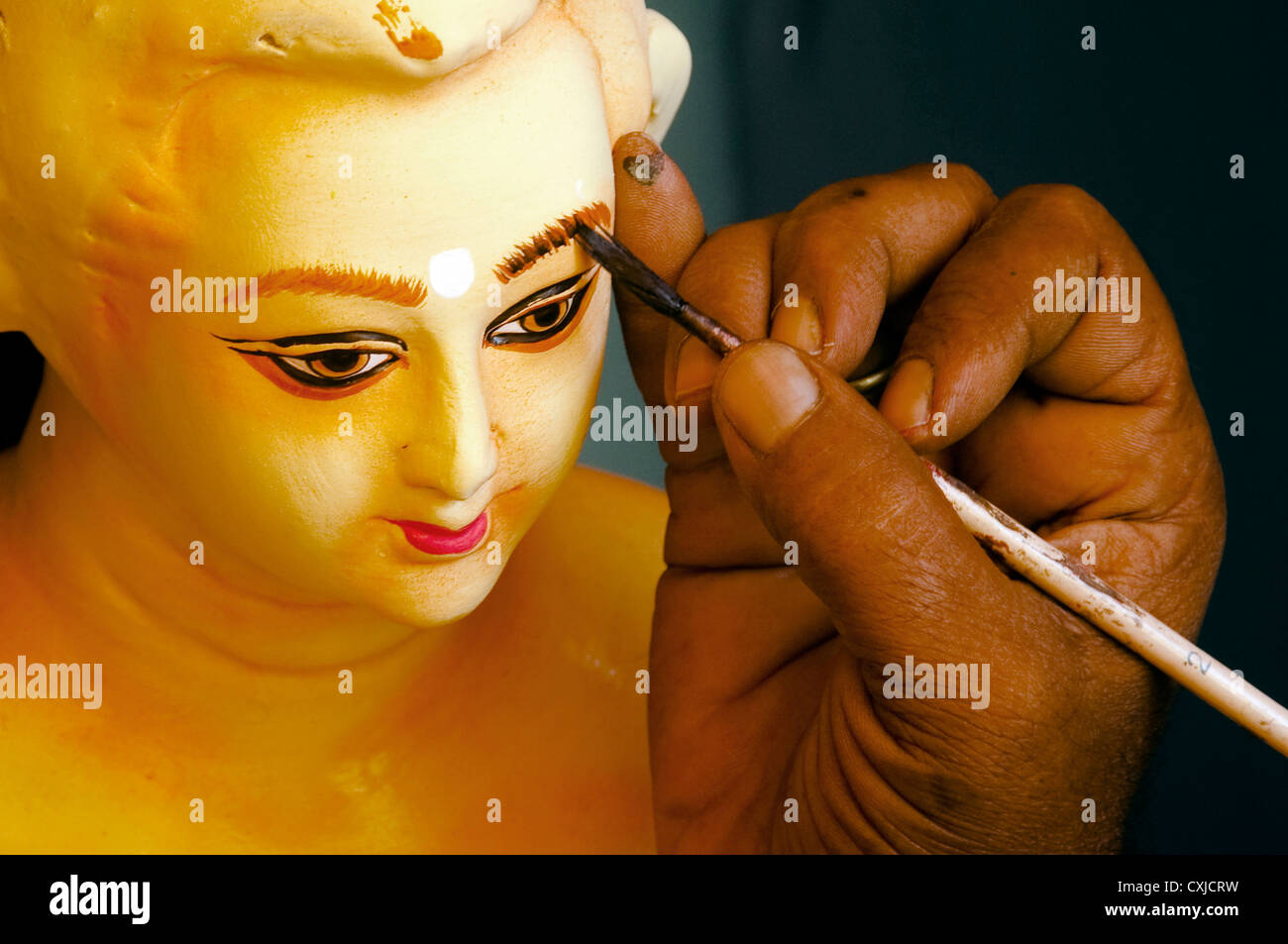 Die Malerei arbeitet am Gesicht des tönernen Idols des Hindu-Gottes in Kumortuli, Westbengalen, Indien. Stockfoto