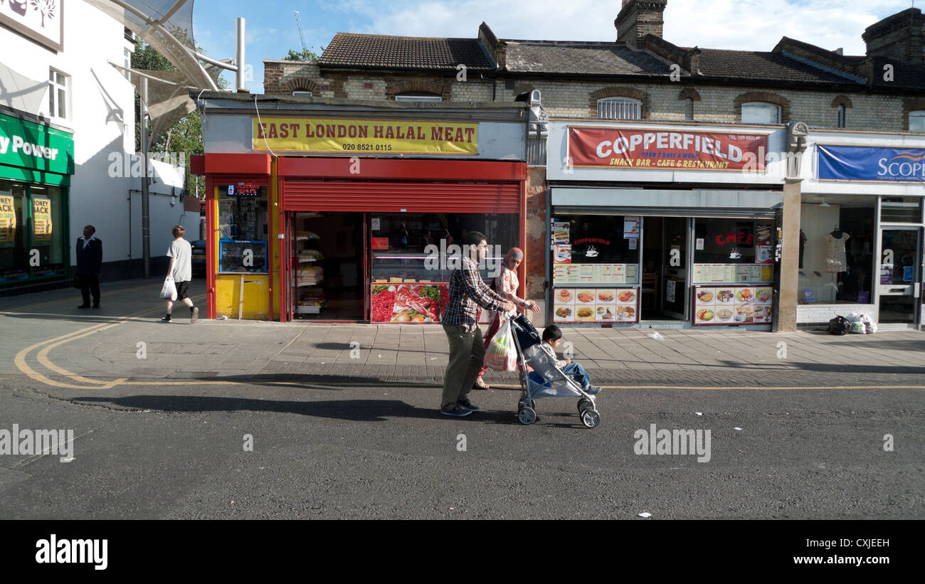 Eine Familie, die zu Fuß vorbei an der East London Halal Fleisch Store Walthamstow London England UK Stockfoto