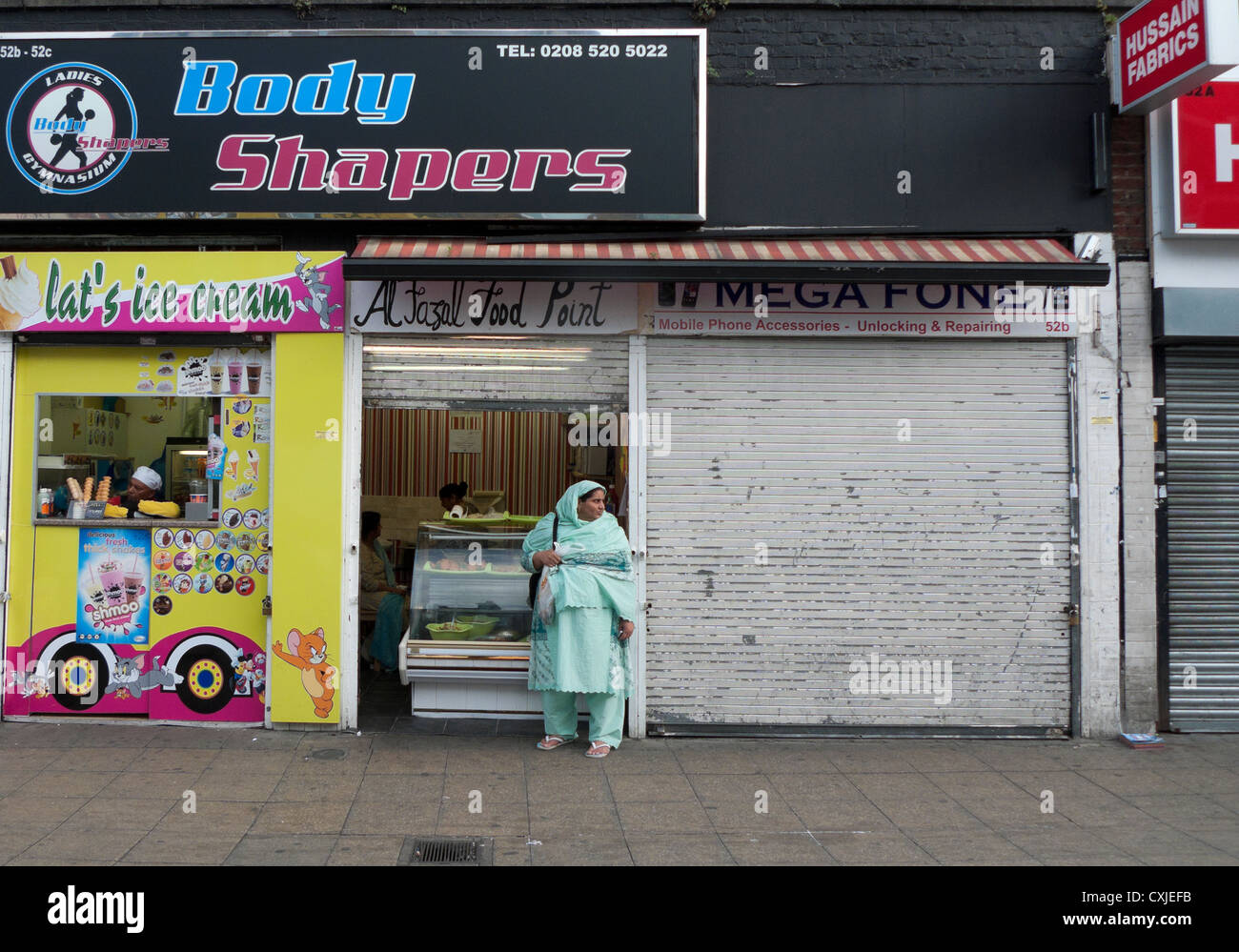 Body Shaper Fitnessstudio über Ice Cream Shop und Al Fazal Food Point Shop Walthamstow HIgh Street London England KATHY DEWITT Stockfoto