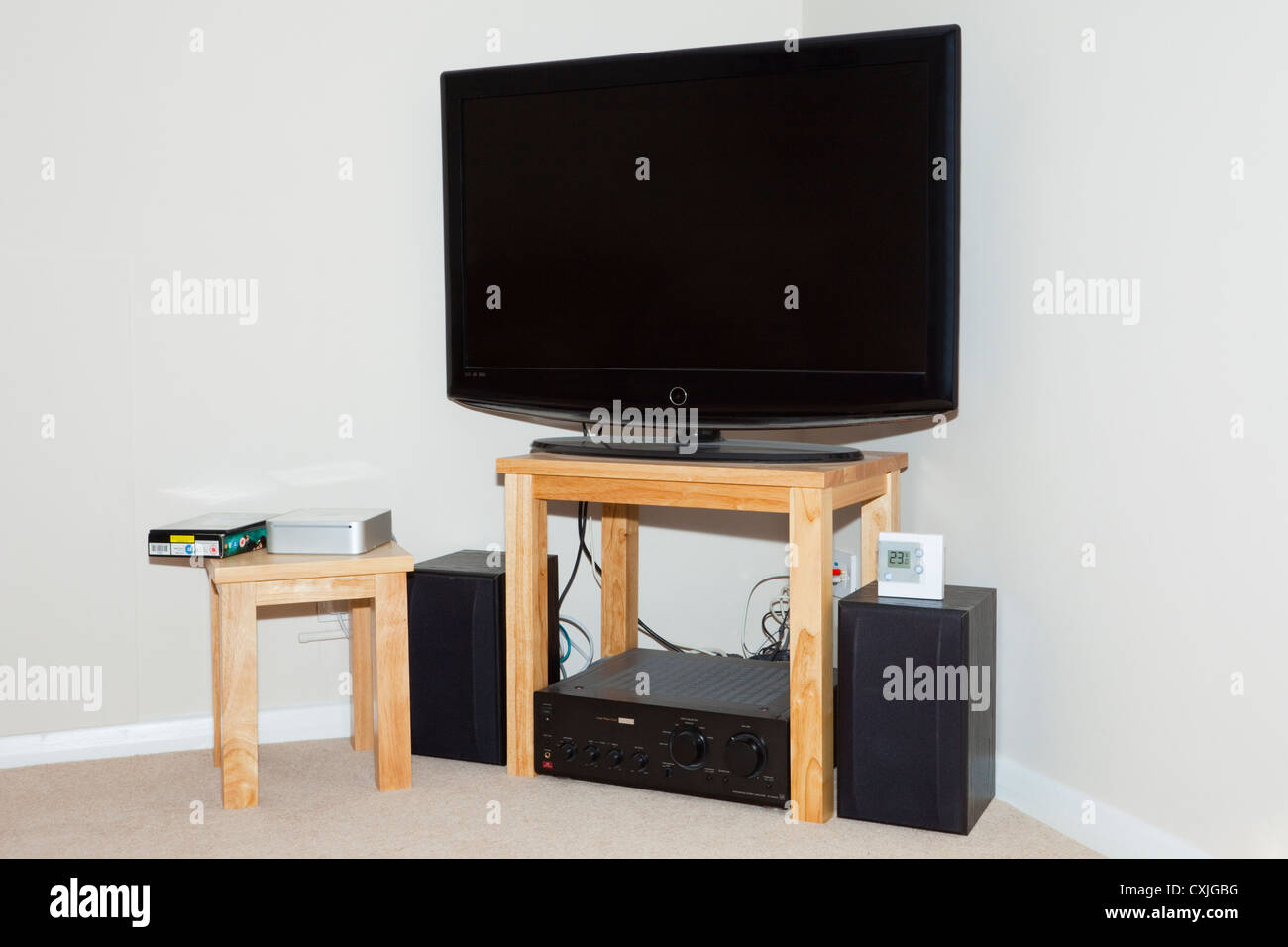 UK, Großbritannien. Flachbildschirm-Fernseher und Lautsprecher in der Ecke eines Wohnzimmers Stockfoto