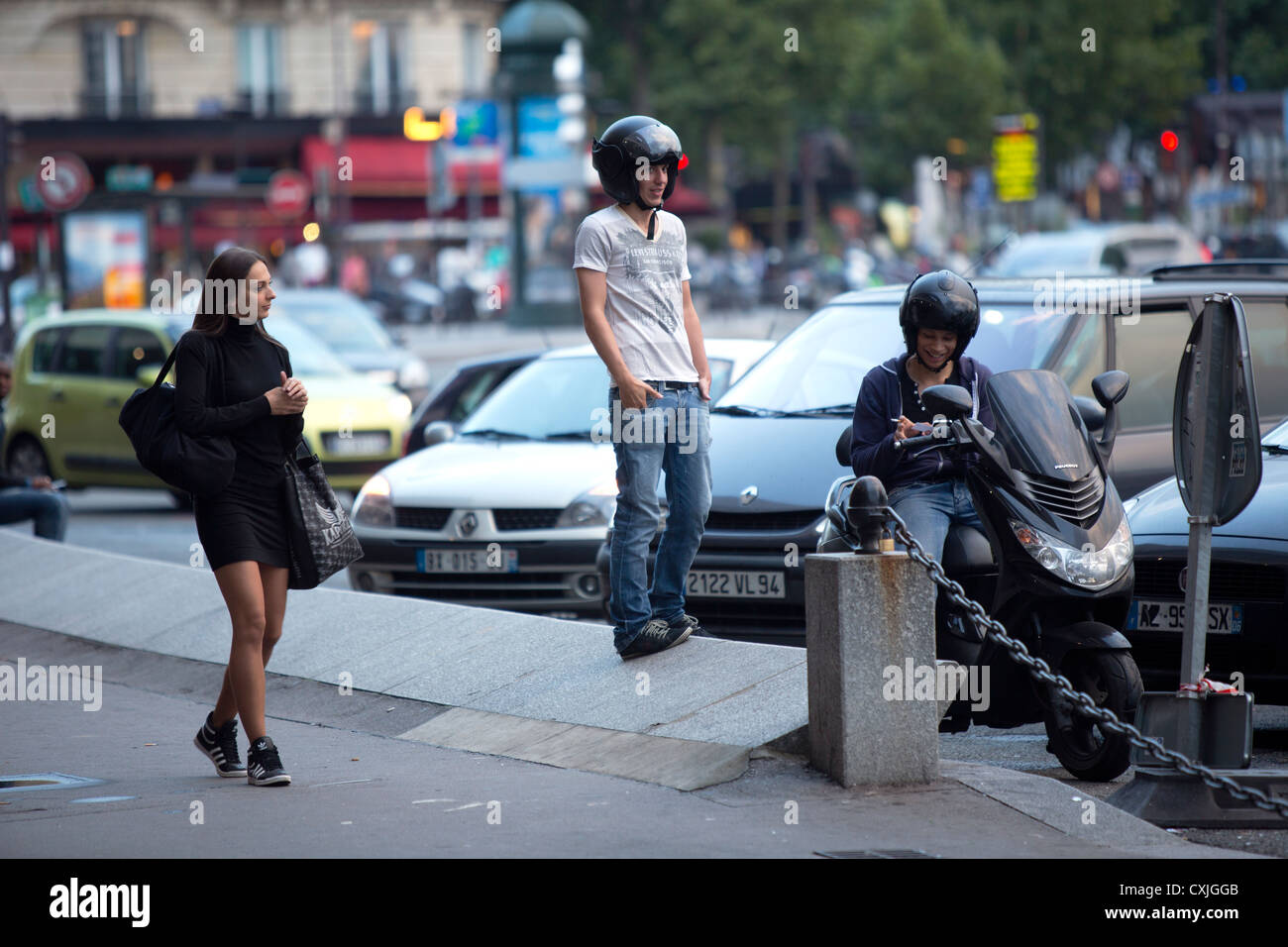 Paris Frankreich eine junge Dame, vorbei an zwei junge männliche Rollerfahrer Stockfoto