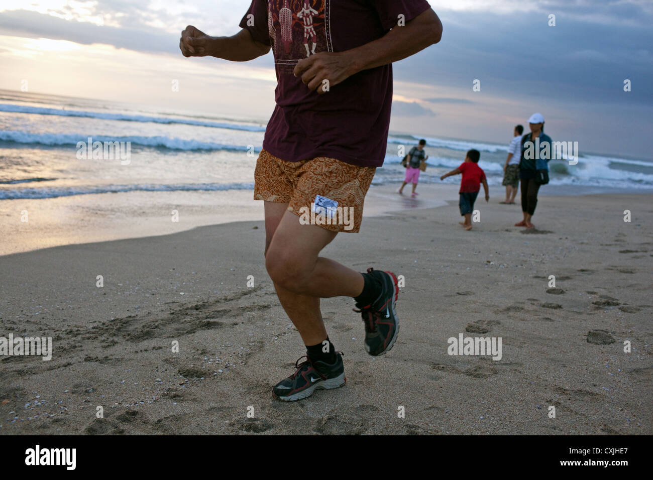 Menschen Joggen am Kuta Beach, Kuta, Bali, Indonesien Stockfoto