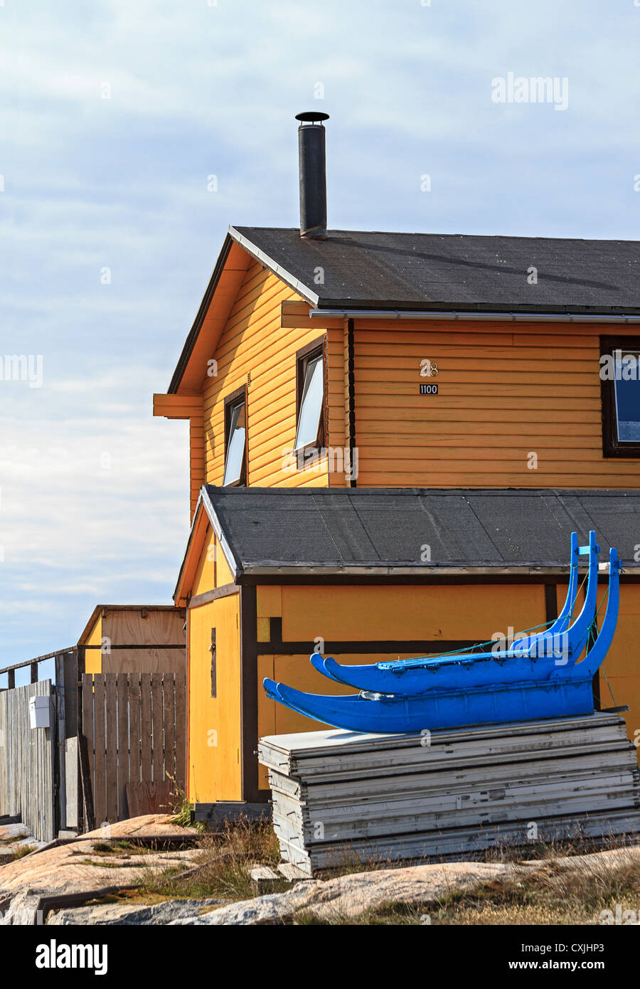 Bunte Hundeschlitten sitzt draußen ebenso bunten Haus in Ilulissat, Grönland Stockfoto