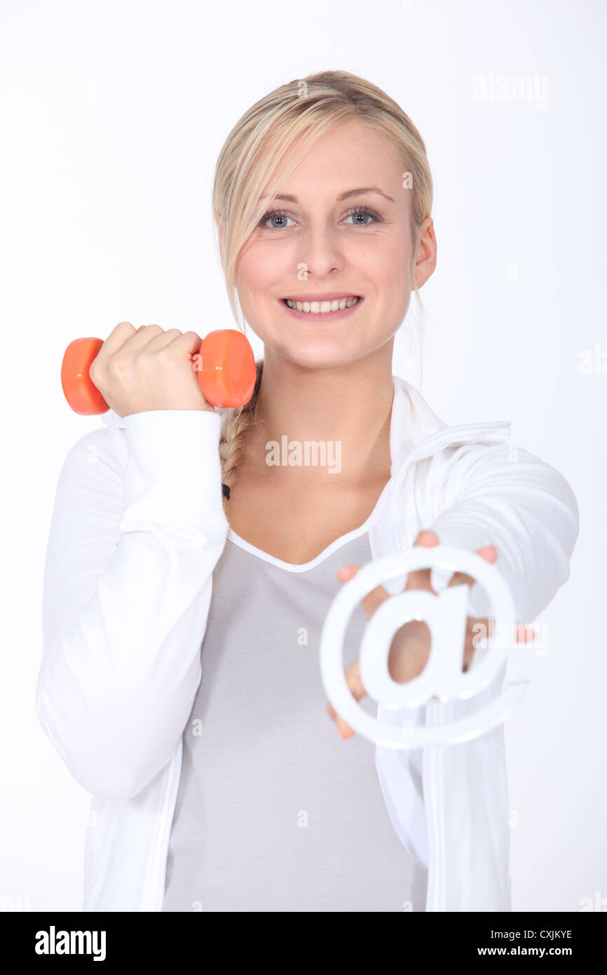 Junge Frau mit einer Hantel und ein Internet @-Zeichen Stockfoto