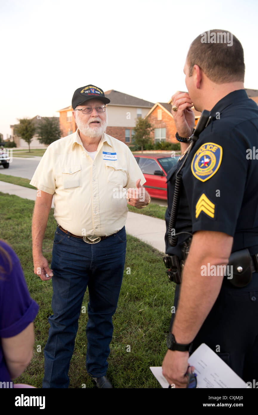 Familien versammeln sich am Stadtteilpark mit der Polizei für die jährliche nationale Night Out Zusammenkunft zur Interaktion mit Nachbarn sprechen Stockfoto