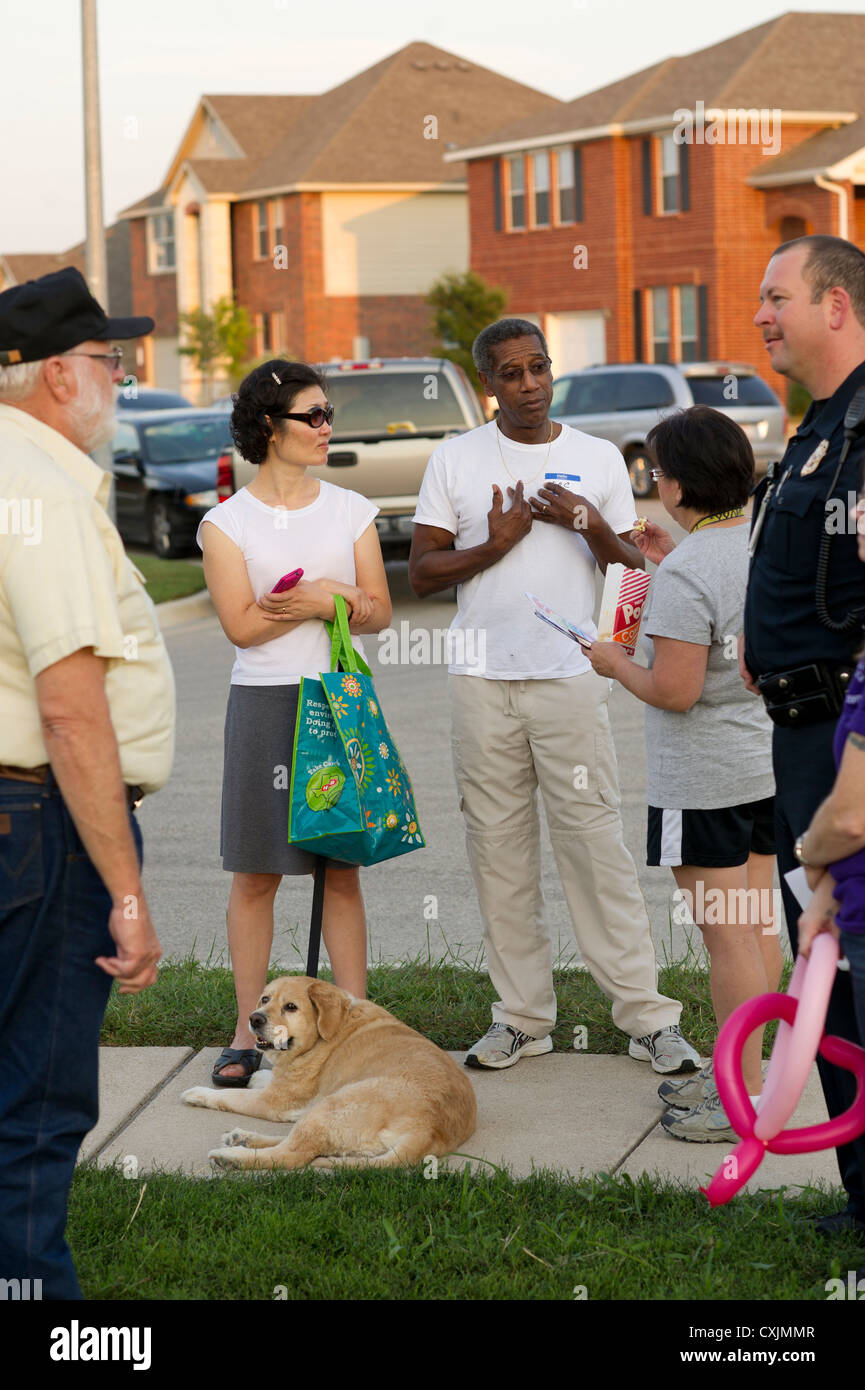 Familien versammeln sich am Stadtteilpark mit der Polizei für die jährliche nationale Night Out Zusammenkunft zur Interaktion mit Nachbarn sprechen Stockfoto