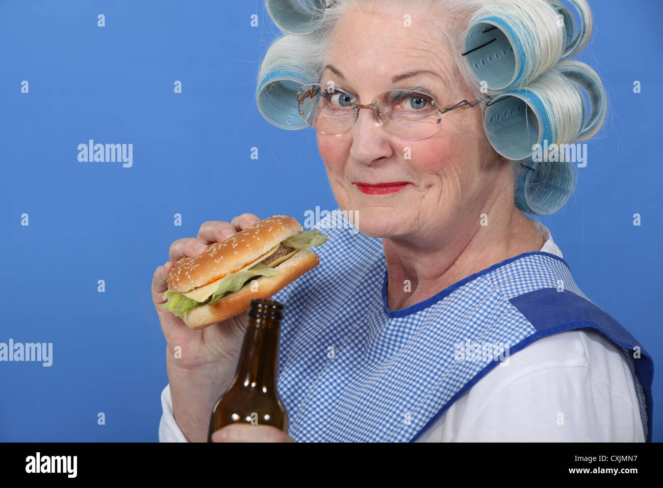 Oma einen Burger Essen und trinken ein Bier Stockfoto