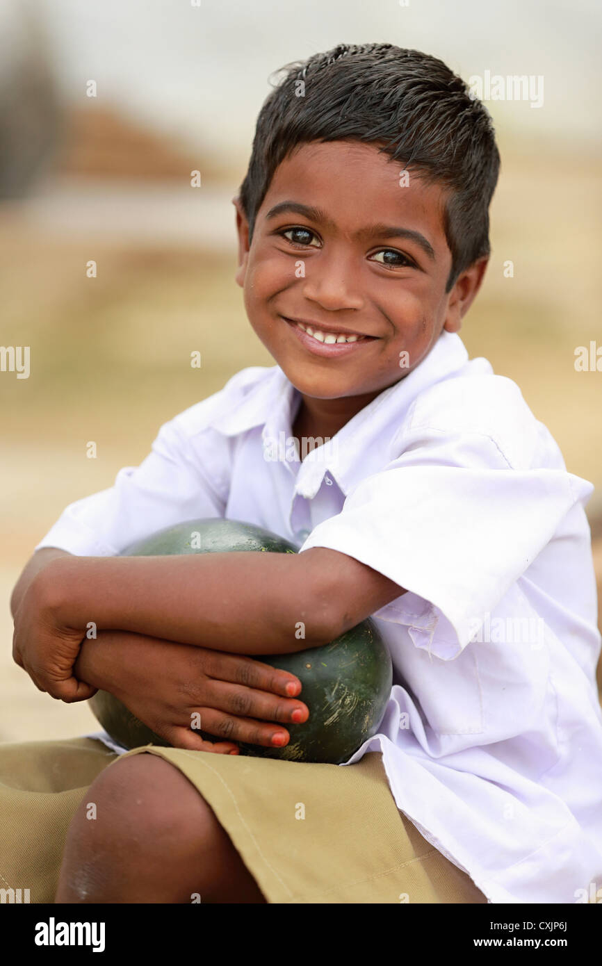 Niedlichen indische Schuljunge hält eine Wassermelone Andhra Pradesh in Indien Stockfoto