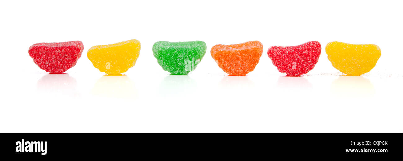 Reihe von verschiedenen farbigen Gummibärchen Bonbons auf weißem Hintergrund mit Textfreiraum Stockfoto