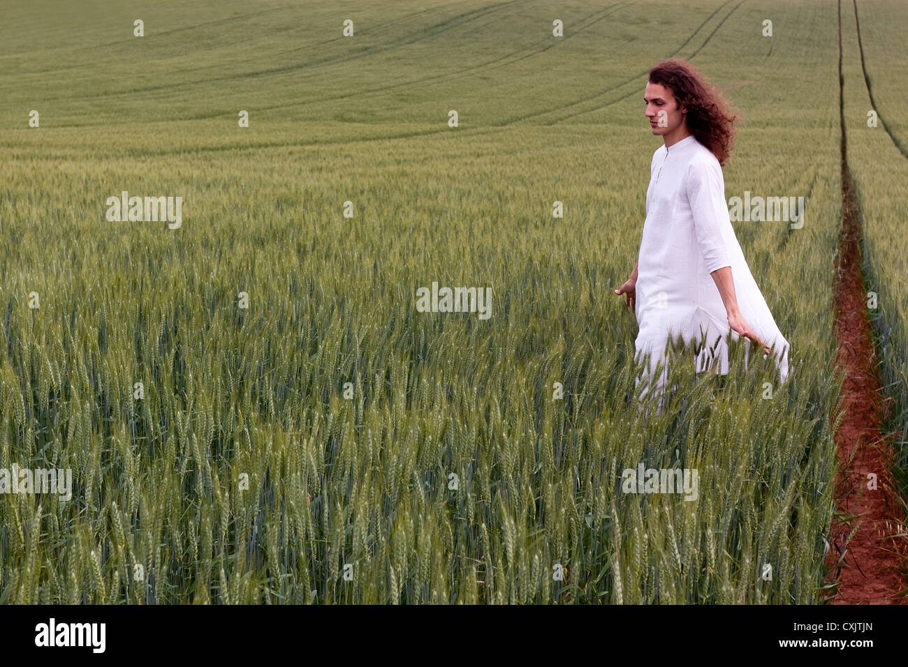 Spirituelle Tagträumer schreiten durch ein Kornfeld Stockfoto