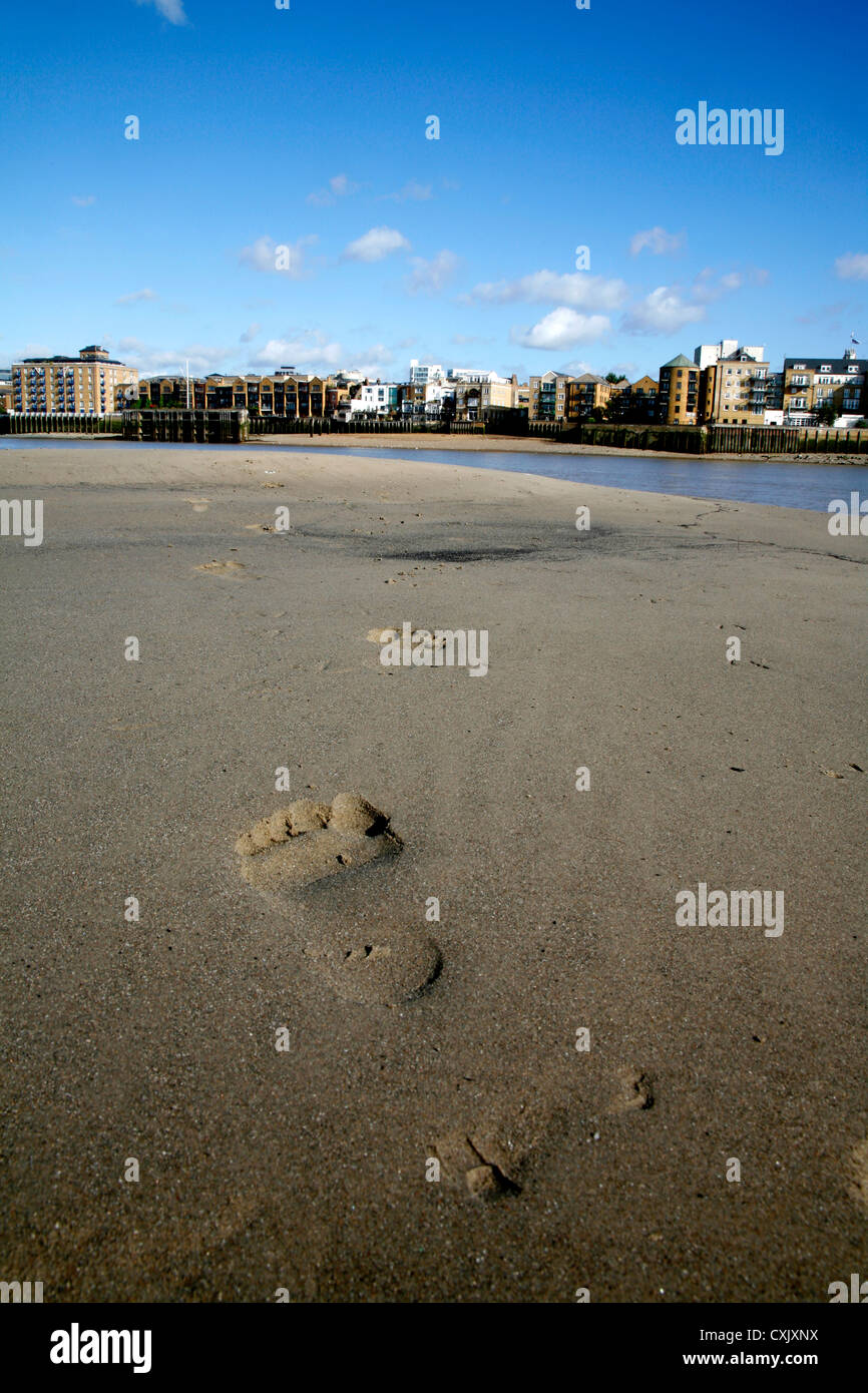 Sandstrand bei Ebbe auf der Themse bei Rotherhithe, London, UK offenbart. Limehouse kann in der Ferne gesehen werden. Stockfoto