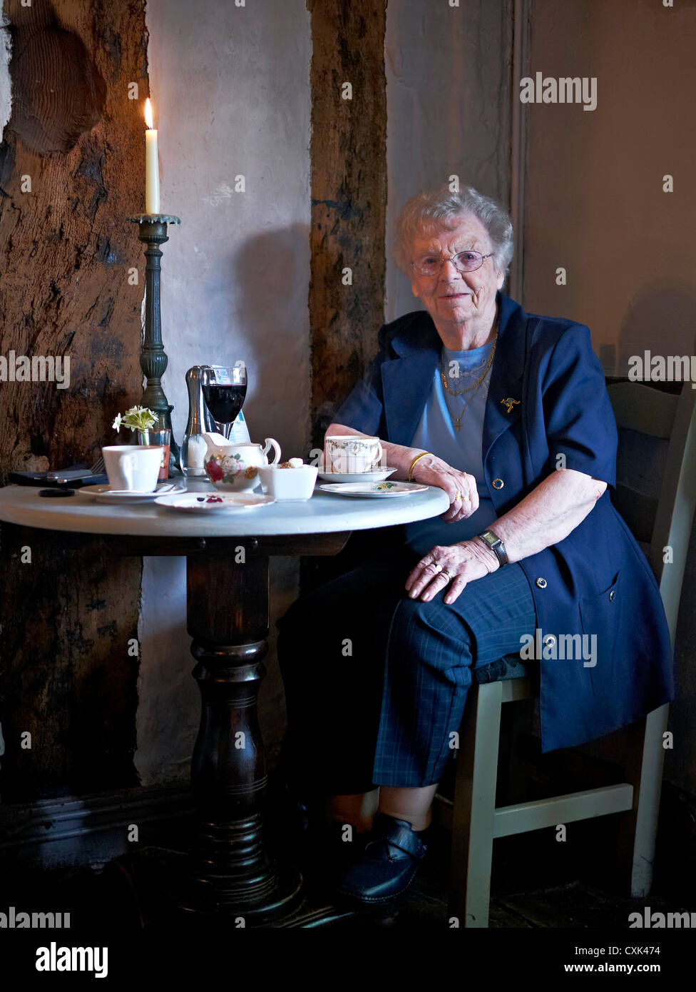 90-jährige, nicht-agenarische englische Dame, die ihren Geburtstag mit einem Glas Rotwein in einem Candlelight-Restaurant feiert. England, Großbritannien Stockfoto