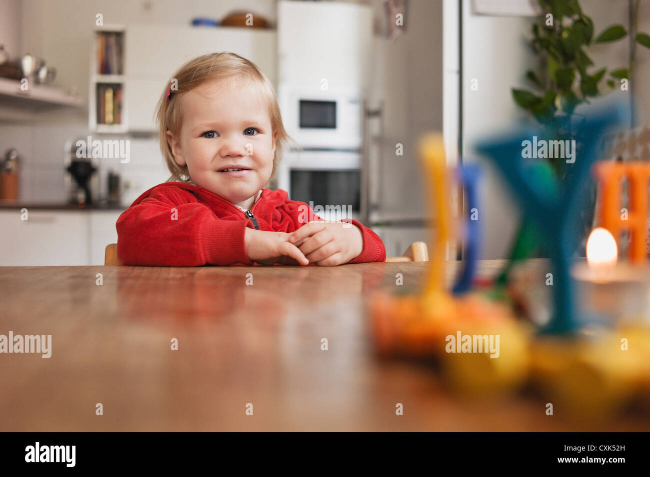 Porträt von kleinen Mädchen, die am Tisch sitzen Stockfoto