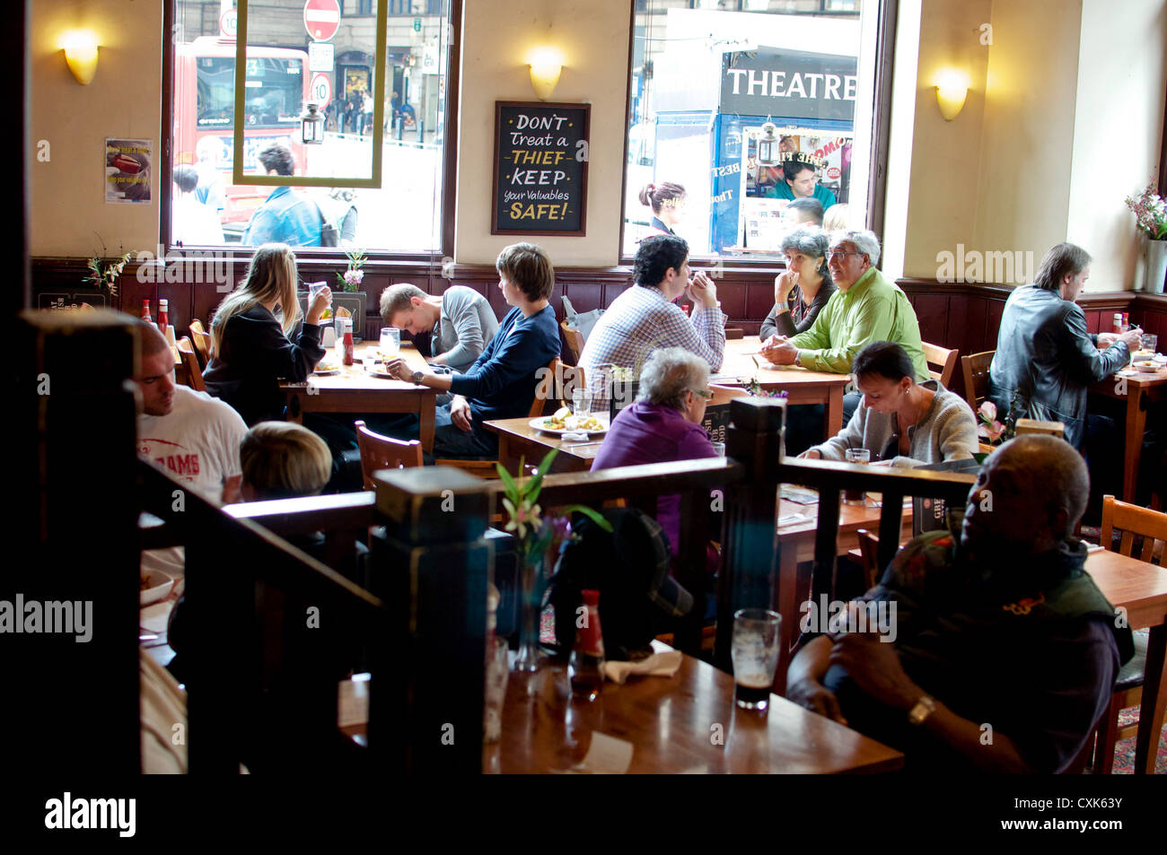 London Pub Diners mit Warnschild über Diebe an der Wand. Nicht identifizierte Personen. Öffentlichen Ort. Redaktionelle Nutzung. Stockfoto